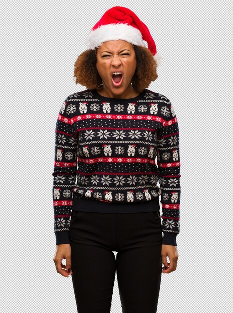 Junge schwarze Frau in einer modischen Weihnachtsstrickjacke mit Druck sehr verärgert und aggressiv schreiend