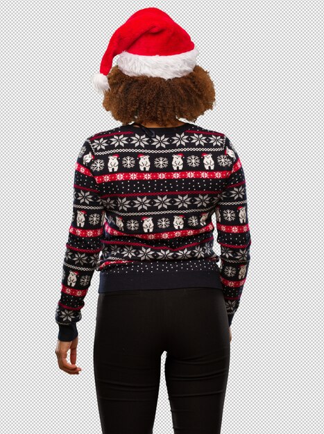 Junge schwarze Frau in einer modischen Weihnachtsstrickjacke mit Druck von hinten, zurück schauend