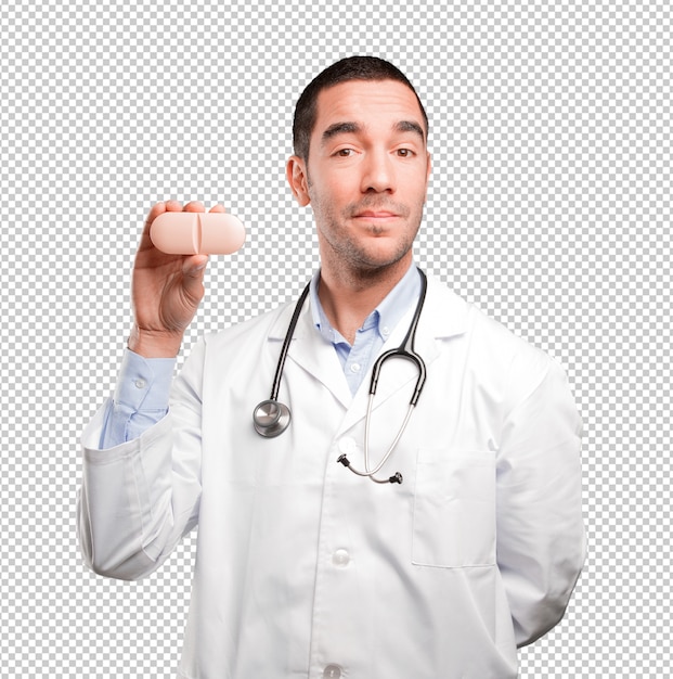 Junger Doktor, der eine Pille anhält