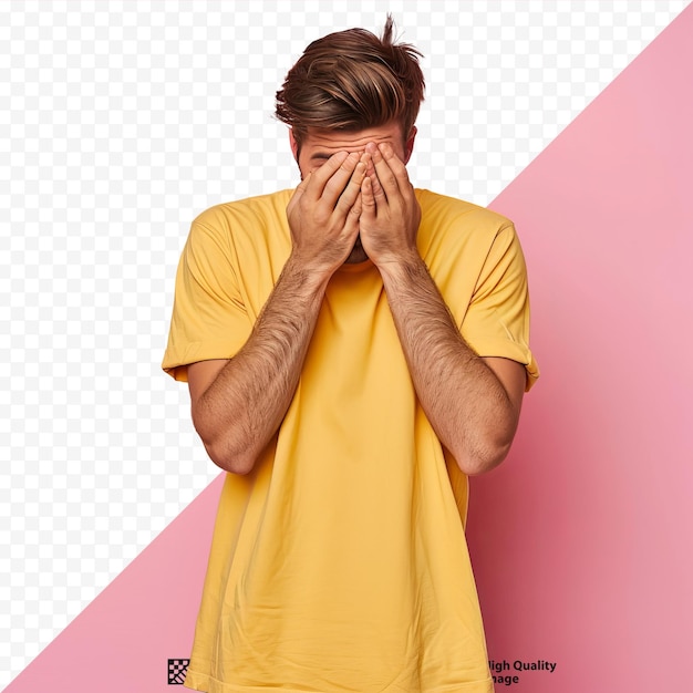 PSD junger, gutaussehender mann in einem gelben, beiläufigen t-shirt steht über einem isolierten, rosa, isolierten hintergrund mit traurigem gesichtsausdruck und bedeckt sein gesicht mit händen, während er weint.