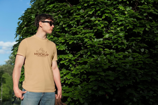 Junger Mann, der draußen ein Mock-up-T-Shirt trägt