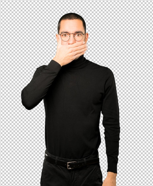 Junger Mann, der seinen Mund mit seinen Händen bedeckt