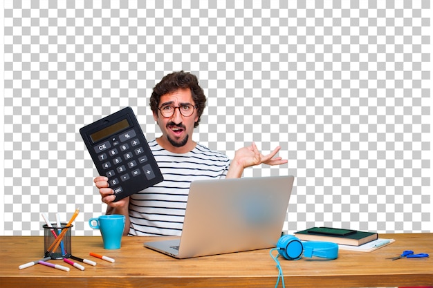 Junger verrückter Grafikdesigner auf einem Schreibtisch mit einem Laptop und mit einem Taschenrechner
