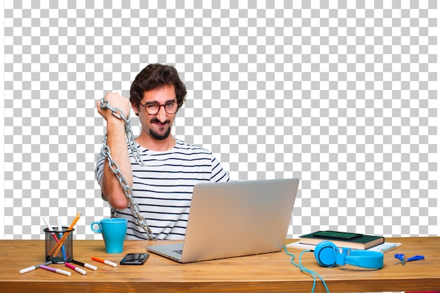 Junger verrückter Grafikdesigner auf einem Schreibtisch mit einem Laptop und mit einer Kette. Freiheitskonzept