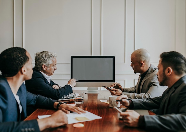 Junta directiva discutiendo un plan de negocios en la computadora