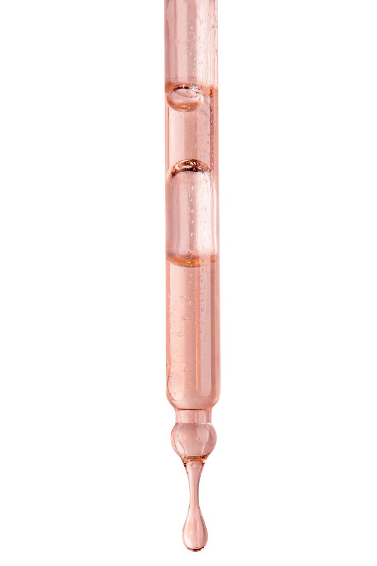 PSD kosmetische pipette mit rosa flüssigkeit tropft auf einem leeren hintergrund säuren beere extrakt serum serum