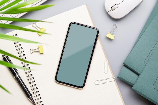 Kreatives Modell Smartphone flach legen Foto von Arbeitsbereich Schreibtisch