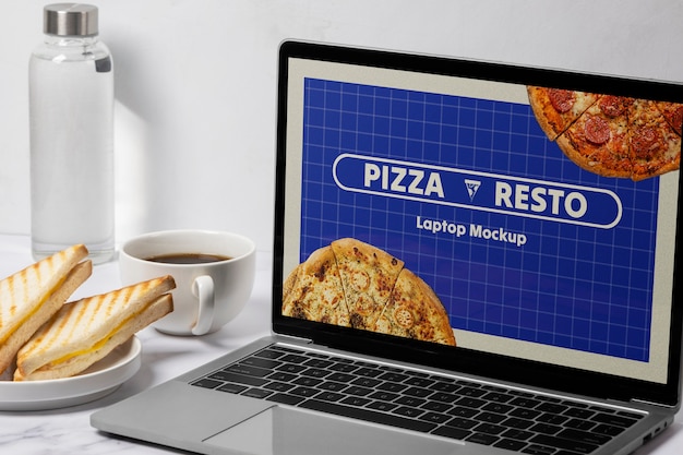 Laptop y comida en la mesa