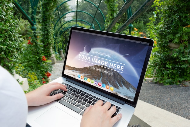 Laptop, der auf Frauenknie im Parkmodell legt