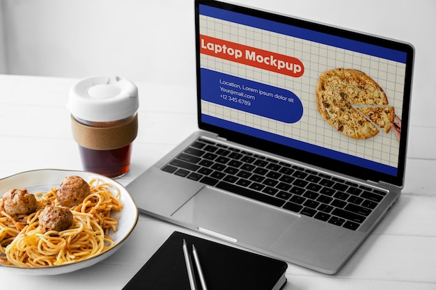 Laptop e comida na mesa