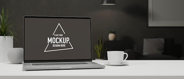 Laptop mit Mockup-Bildschirm auf weißem Tisch mit Tasse und Dekorationen