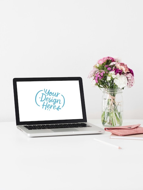 Laptop-Mockup mit Blumen und rosa Zubehör