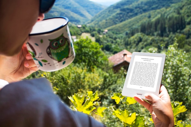 Leitor de e-book, maquete, menina tomando café, fundo ao ar livre, caneca