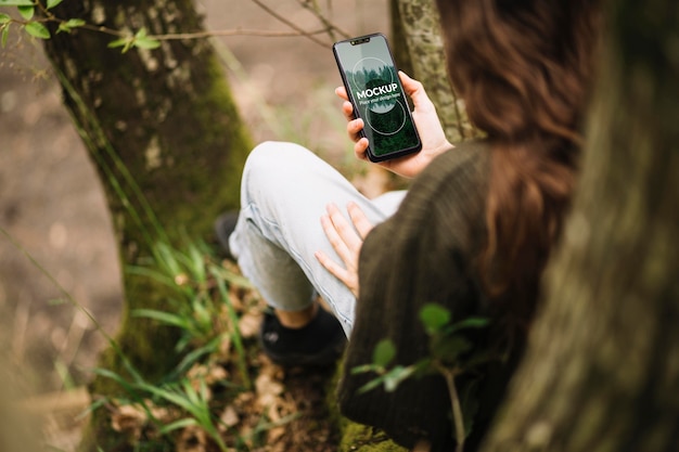 PSD linda mujer en la naturaleza con maqueta de smartphone