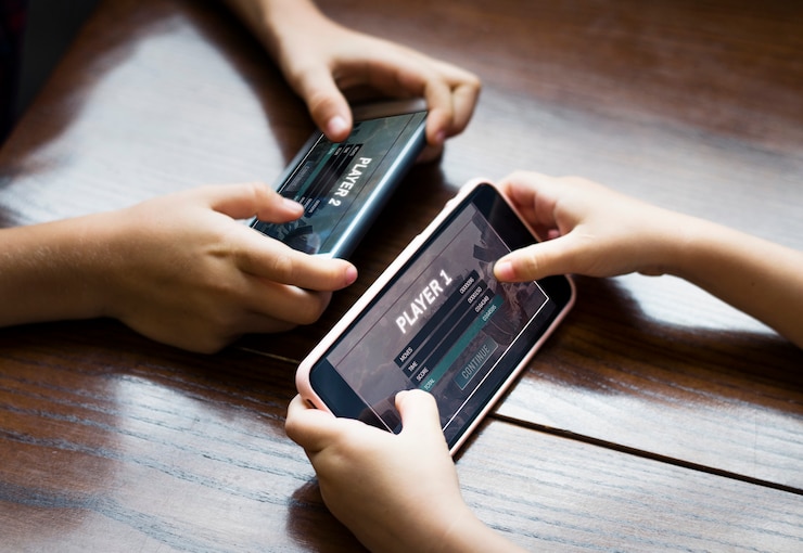 PSD little boy playing a mobile game against his sister