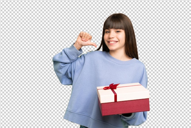 Little girl holding a gift over isolated chroma key background proud and selfsatisfied