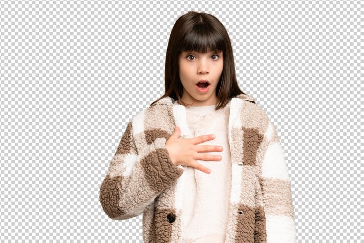 PSD little girl over isolated green chroma key background surprised and shocked while looking right