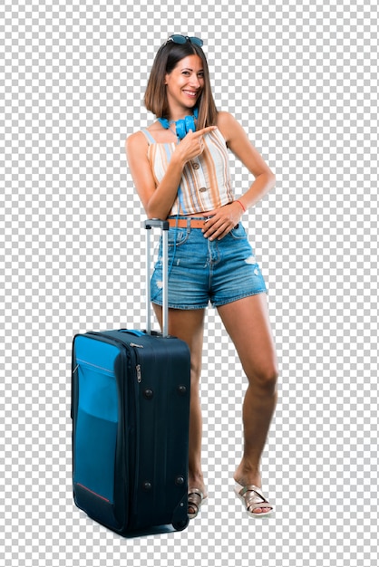 Mädchen, das mit ihrem koffer fährt, der finger auf die seite zeigt und ein produkt darstellt