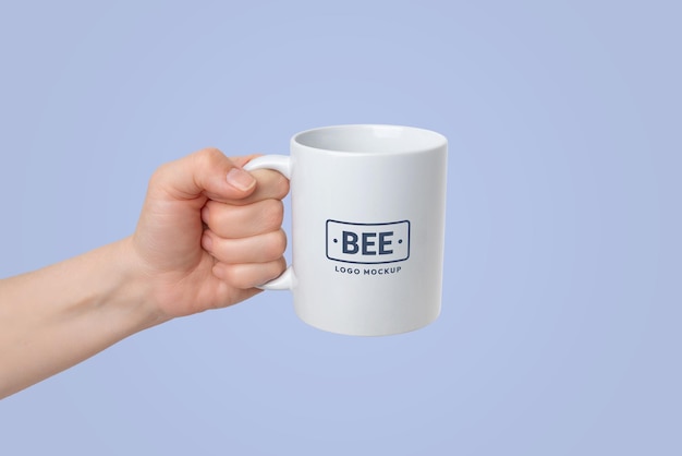 PSD main avec tasse blanche pour la promotion du logo avec fond changeant