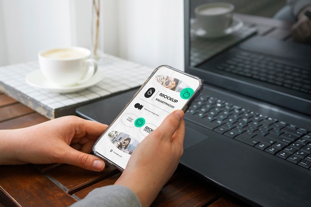 Mani ad alto angolo con smartphone e caffè