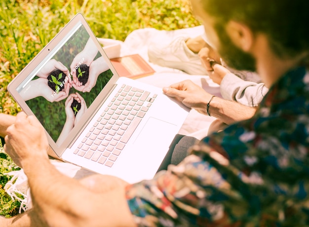 PSD mann, der laptopmodell in der natur verwendet