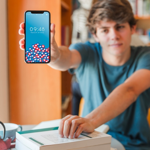 PSD mann, der smartphonemodell in der bibliothek hält