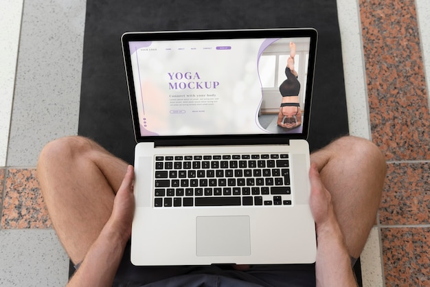 PSD mann, der yoga mit laptop-mockup-design macht