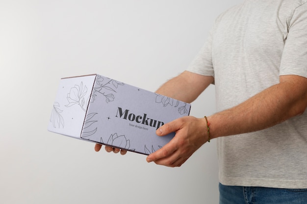 Mann hält Boxen-Mockup-Design