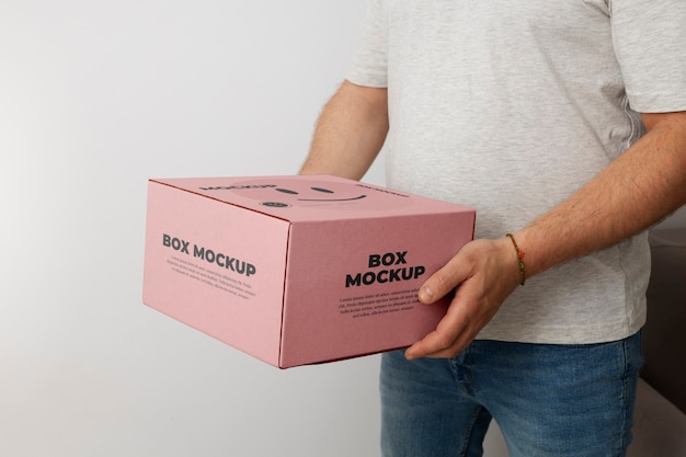 Mann hält Boxen-Mockup-Design