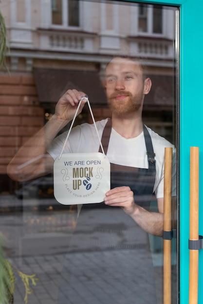 PSD mann hängt, wir sind offenes schild mock-up im geschäftsfenster