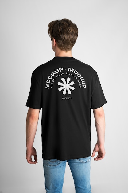 Mann zeigt die Rückseite eines T-Shirt-Modells