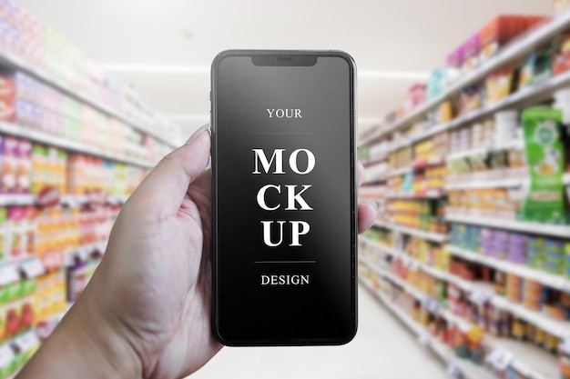 Mano che tiene il mockup mobile nel supermercato