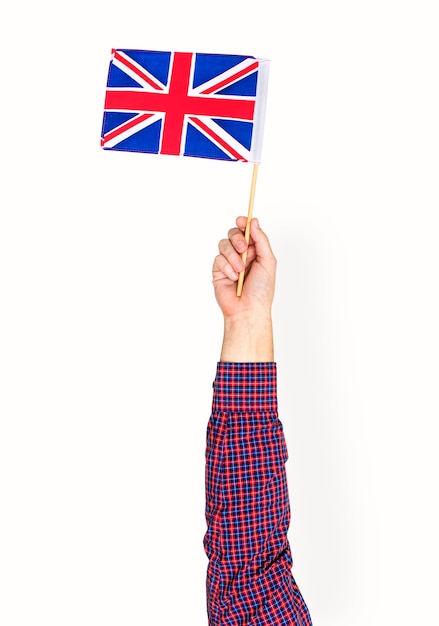 Mano che tiene la bandiera britannica isolato