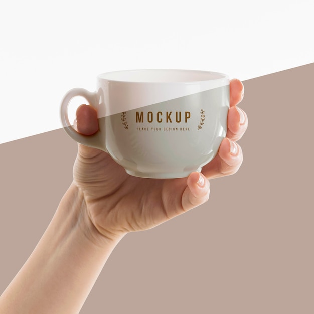 Mano che tiene un mock-up di tazza