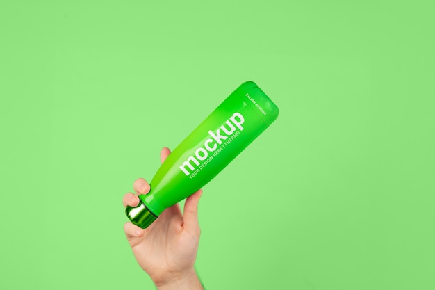 Mano maschio che tiene il modello della bottiglia di thermos verde