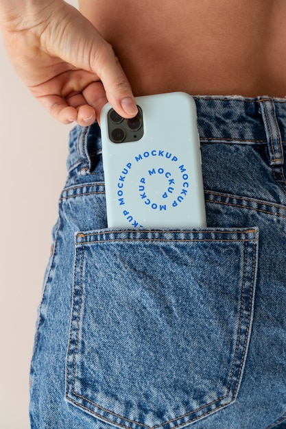 Mano de mujer sosteniendo maqueta de teléfono inteligente en el interior