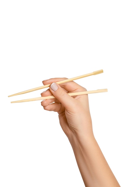 Una mano de mujer sostiene palillos de madera para sushi o rollos sobre un fondo en blanco