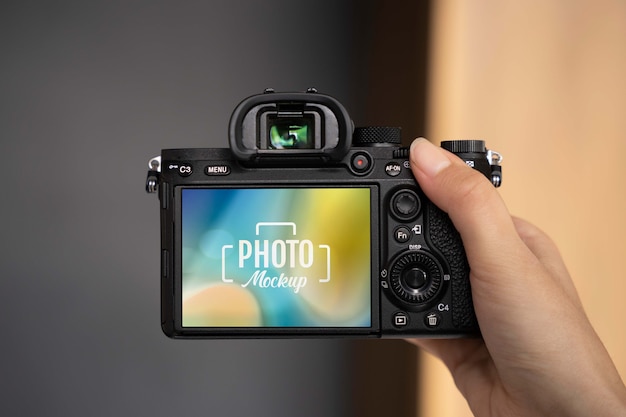 Mano que sujeta la cámara de fotos profesional