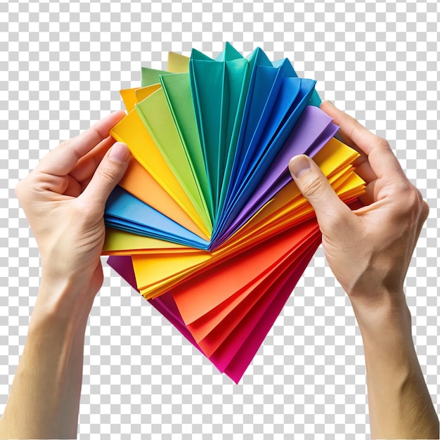 Manos doblando papel de colores aislado sobre un fondo transparente