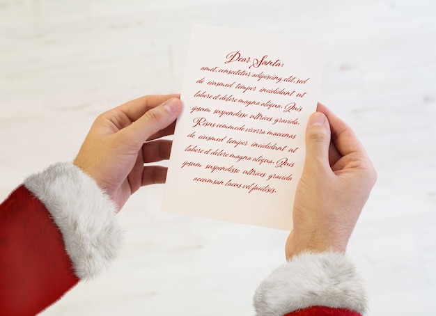 Manos de santa claus sosteniendo una maqueta de carta