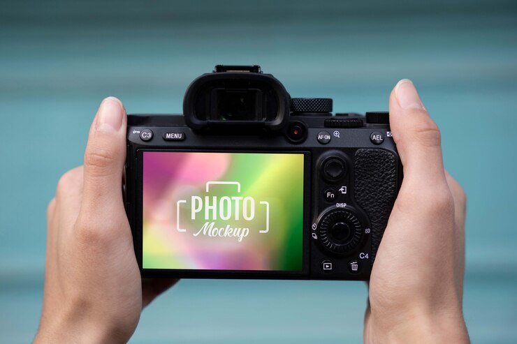 PSD manos sosteniendo una cámara de fotos con fondo azul.