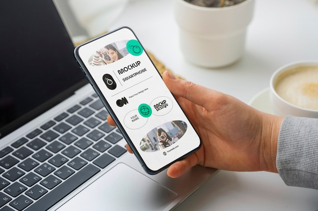 Mão de alto ângulo com smartphone e café