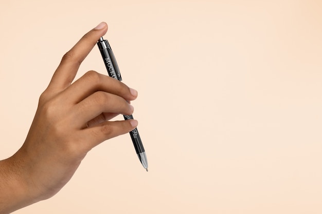 Mão segurando maquete de caneta