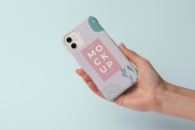 Mão segurando o smartphone com capa de telefone de maquete