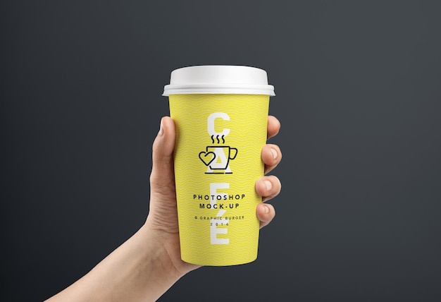 Mão segurando um modelo de xícara de café amarela