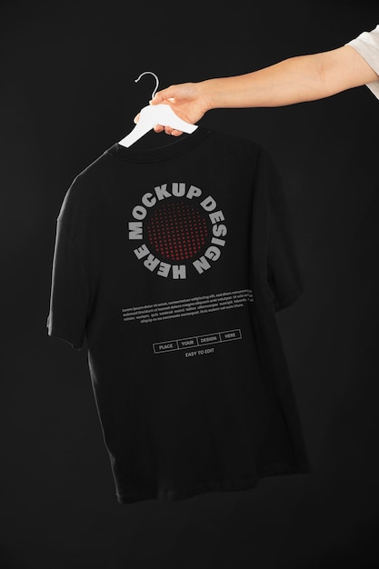 Mão segurando uma camiseta legal em um modelo de cabide