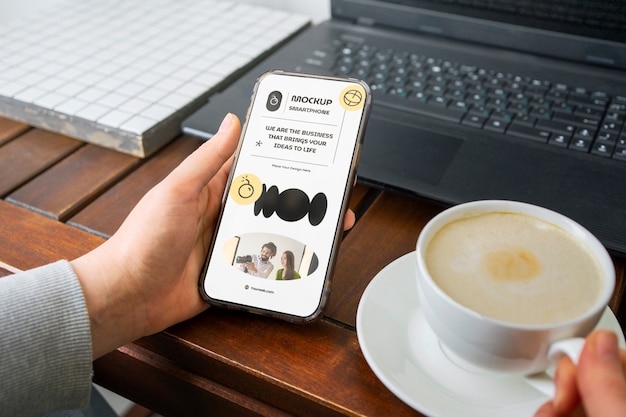 Mãos de alto ângulo com smartphone e café