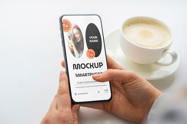 Mãos de alto ângulo com smartphone e café