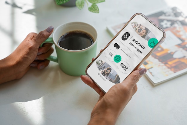 Mãos de alto ângulo com smartphone e café