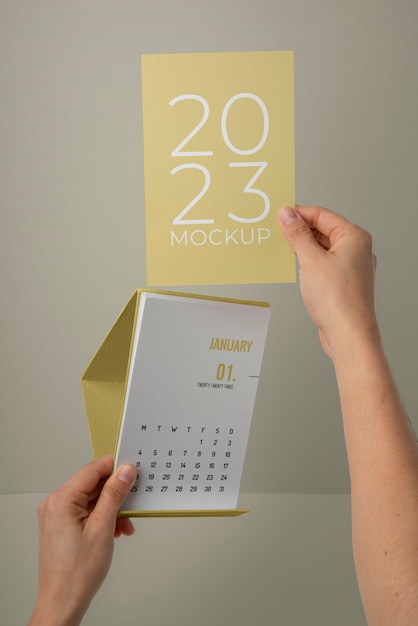 Mãos segurando maquete de calendário